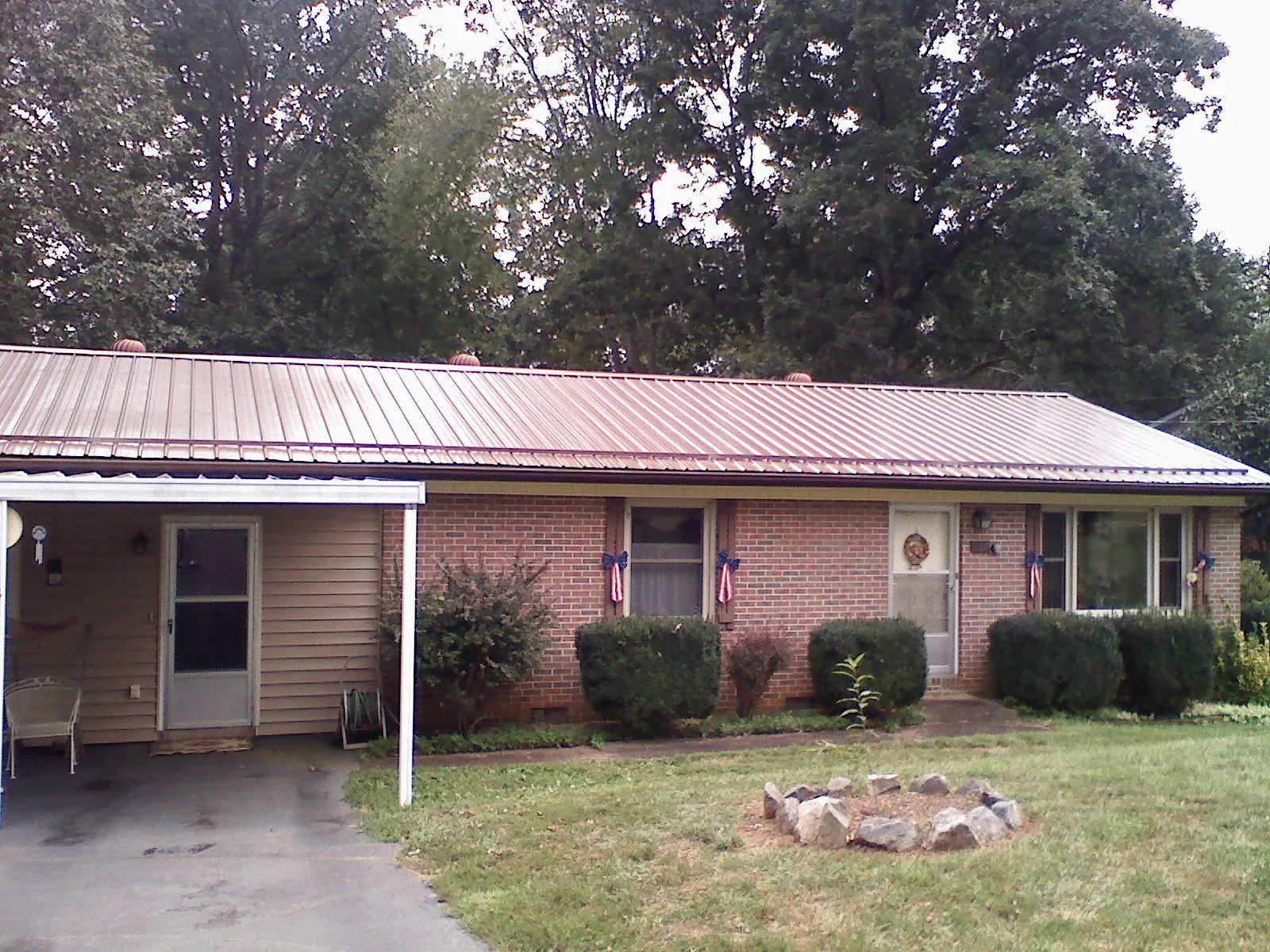 Bronze metal roof and carport on a brick ranch home — Roof Repair work by our crew in Laurel Hill