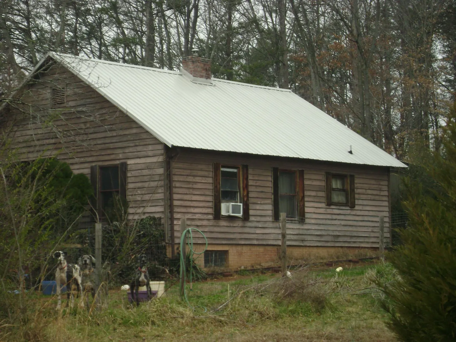 White metal roof on an old wood sided farmhouse, from a Metal Roof Installation job in Laurel Hill